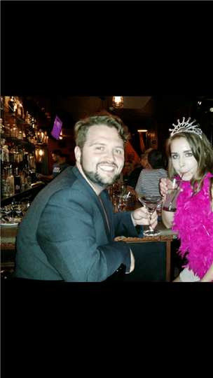 a man posing with a birthday girl who is wearing a tiara and boa