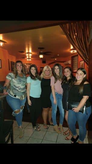 6 women standing and posing while smiling
