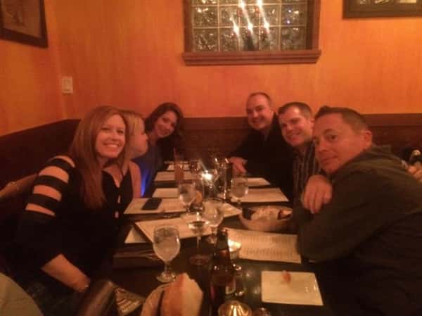 a group of six customers smiling at a table