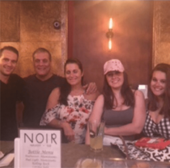 five friends smiling at the bar