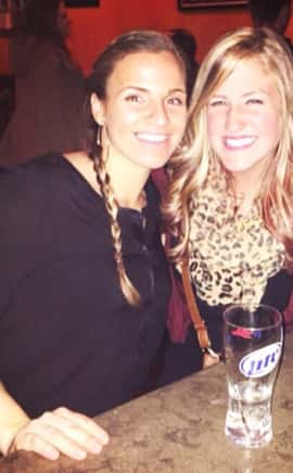 two women smiling with each other at the bar