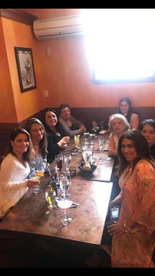 8 customers smiling at their table