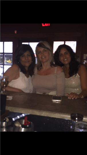 three women smiling at the bar