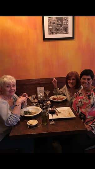 3 women smiling with their plates of food