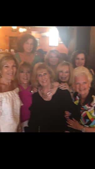 8 happy women smiling with each other