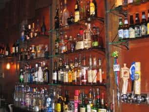 bar area with many liquor bottles shown