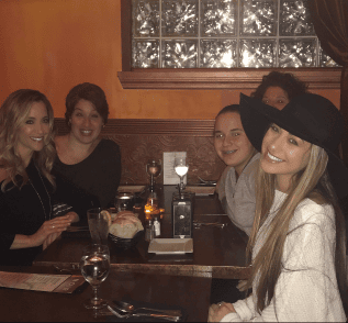 five people smiling at their table