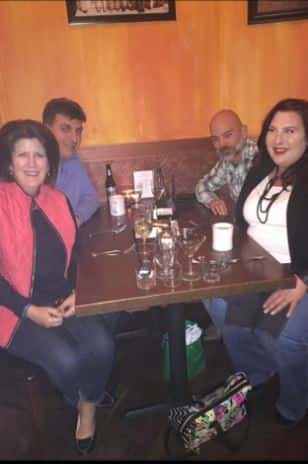 four customers smiling at a table