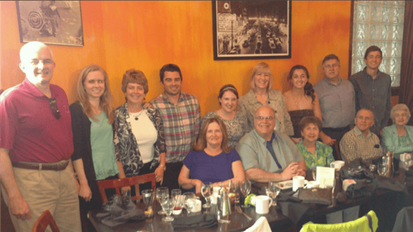 big family smiling at their table