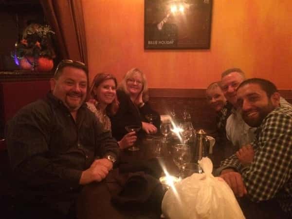 a group of six customers smiling at a table