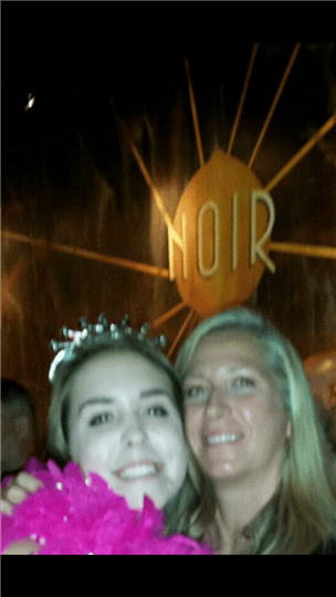 a woman posing with a birthday girl who is wearing a tiara and boa