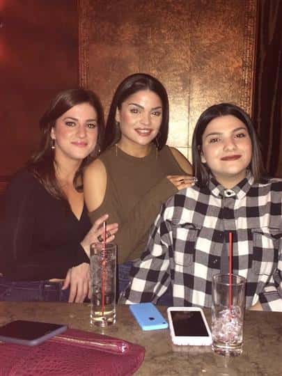 three women smiling together at a bar