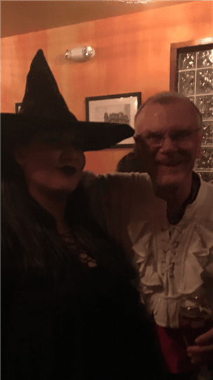 a couple posing together wearing a witch hat