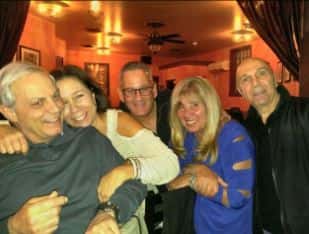 five friends smiling and posing together