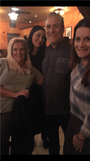 a group of four customers smiling