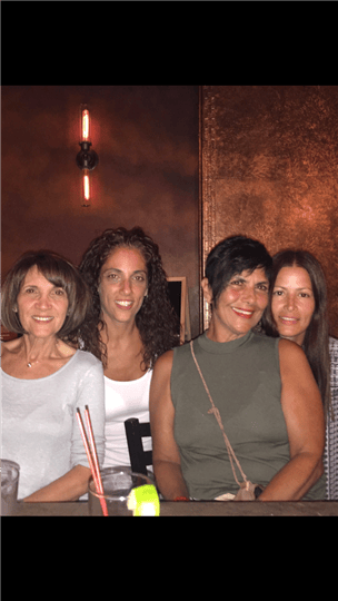 four women smiling at the bar