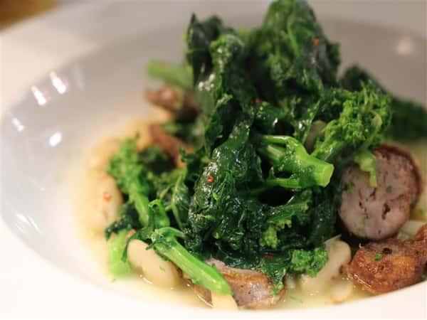 a bed of spinach on top of sausage soup