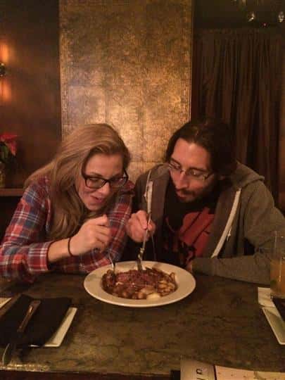 two customers sharing a plate of pasta with red sauce