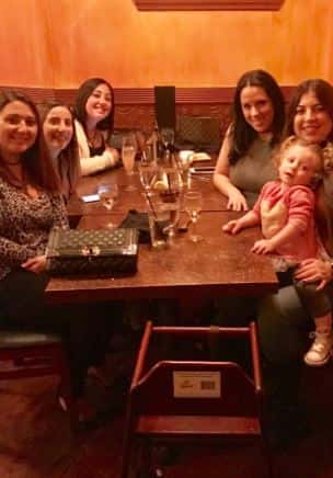 five customers and a baby smiling at a table