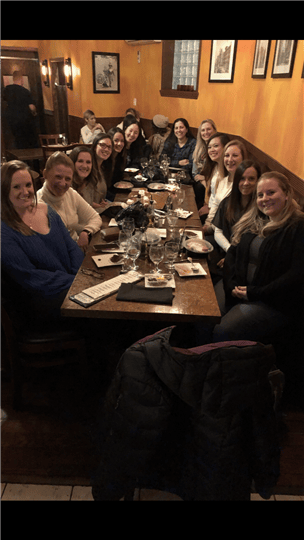 a large table full of happy customers smiling