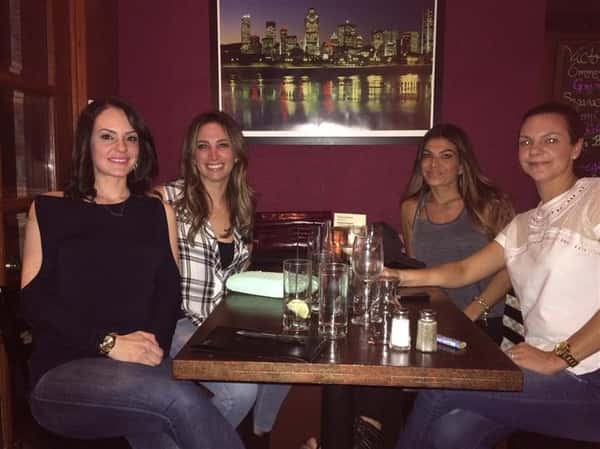 four women smiling at their table