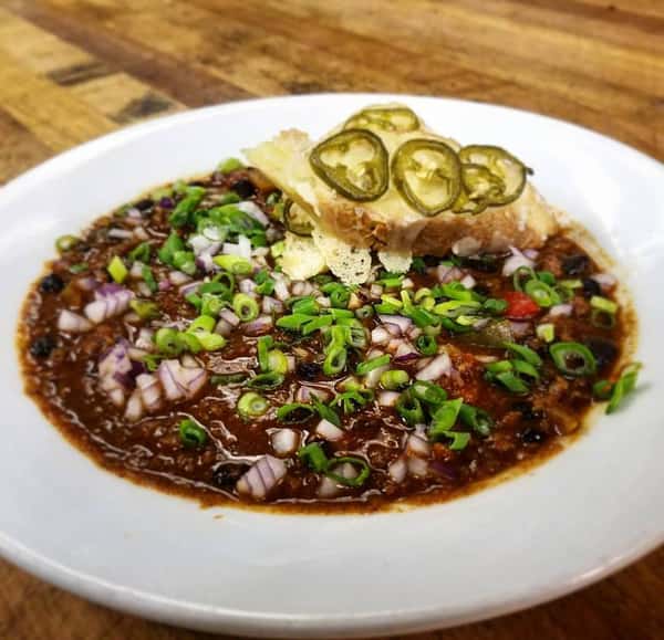 Black bean soup with chopped green onions and jalapeno garlic bread