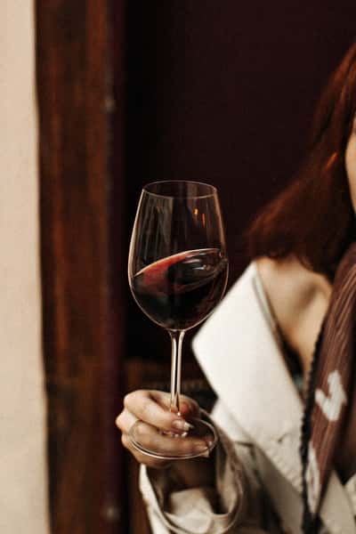 Woman holding a wine glass by the stem