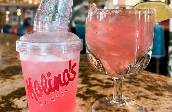 Refreshing pink cocktail served alongside a frozen specialty beverage.
