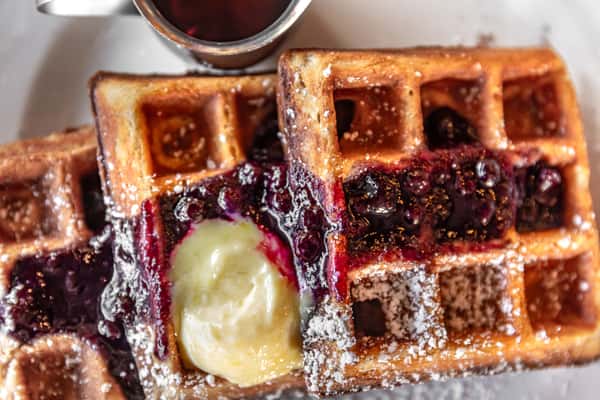 Lemon butter and blueberry compote dress three steaming hot waffles.