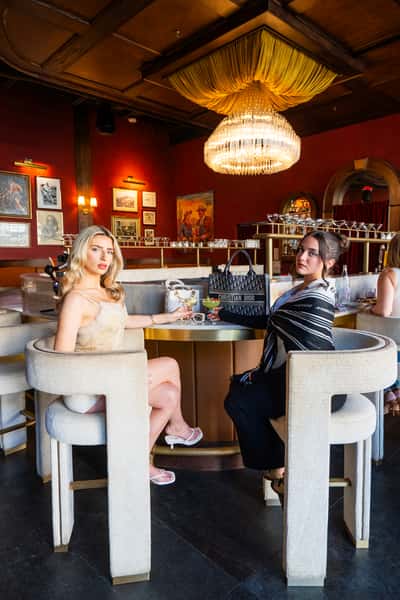 Professional female guest enjoying cocktail service in elegant dining room setting at The Kennedy