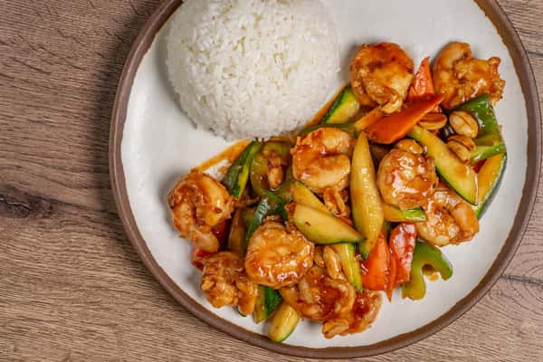 Stir-fried shrimp with vegetables and peanuts in sauce, served with a dome of steamed white rice.