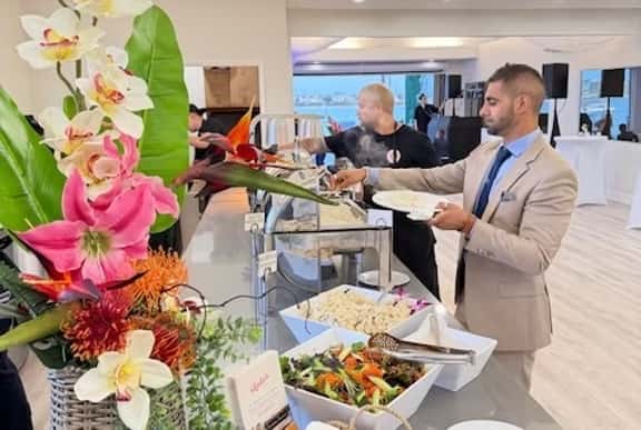 Event guests picking up food from a catered buffet table