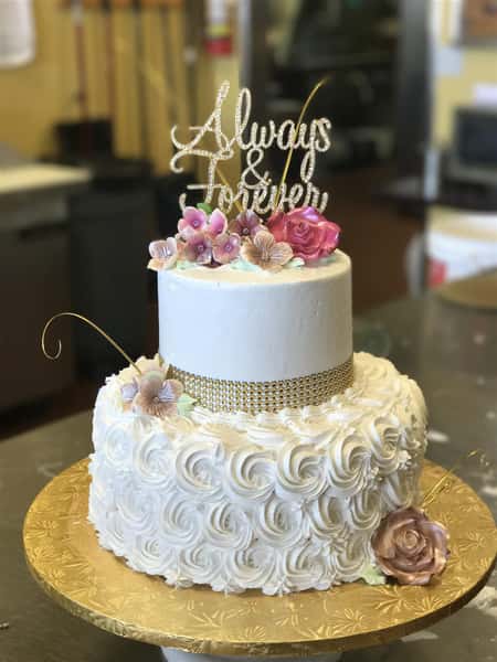 a wedding cake with a topper that says "Always & Forever"