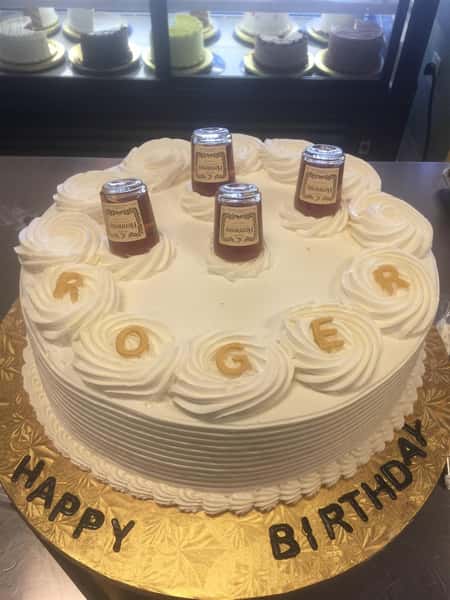 A birthday cake with mini liquor bottles sticking out of the top
