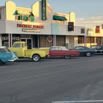 Exterior of Richie Diner with vintage cars parked in front, showcasing a nostalgic retro vibe.
