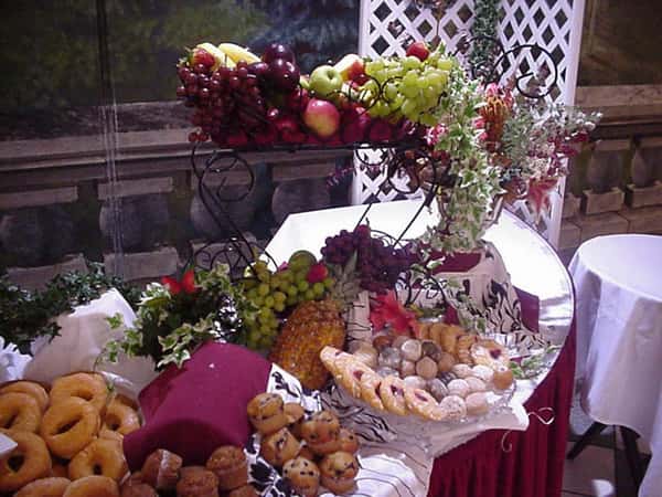 a dessert table with assorted fruits and pastries