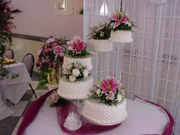 a table with several floral-decorated wedding cakes