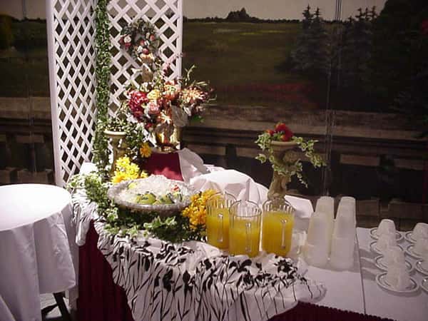 a drink table with cups and pitchers of juice