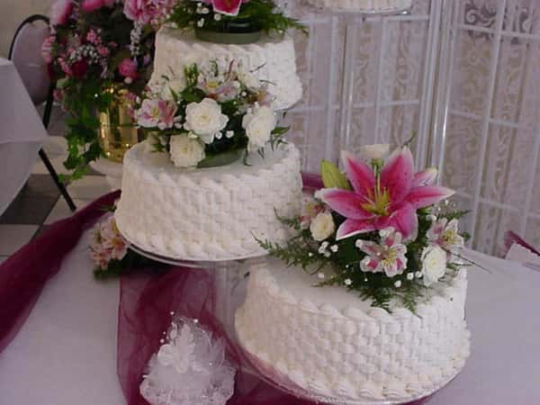 several wedding cakes with floral garnish