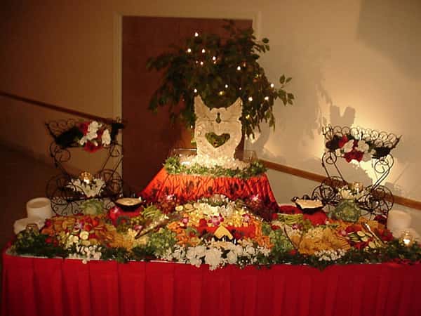 serving table with various fruits and vegetables