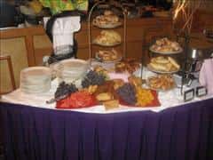 a dessert table with assorted fruits and pastries