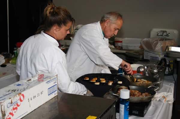 two chefs cooking food in skillets