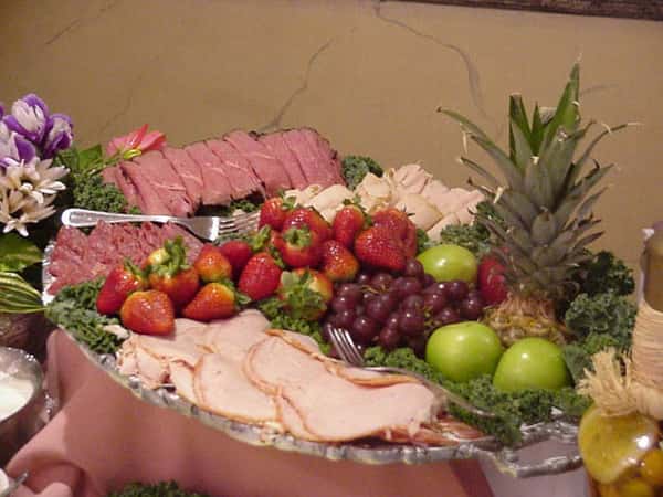 a plate with assorted fruits and cold meats