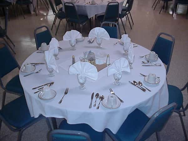 a table set with eating utensils and glasses with fancy folded napkins