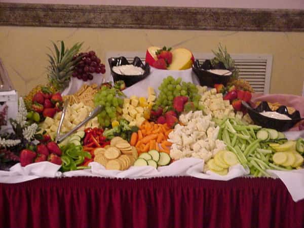 a spread of assorted fruits, vegetables, crackers, cheese and dips