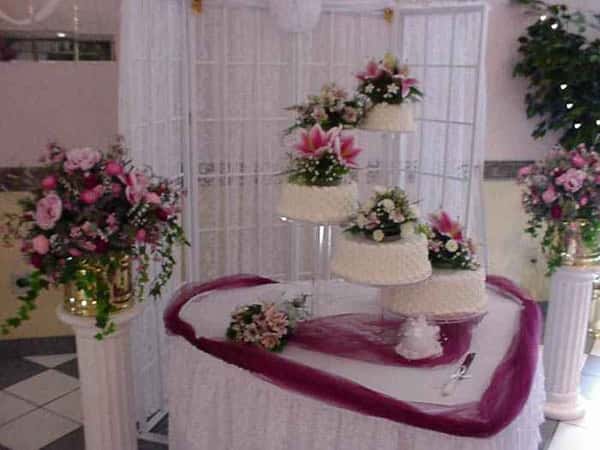 several wedding cakes with floral garnish