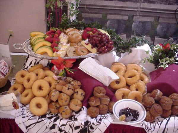 a dessert table with assorted fruits and pastries