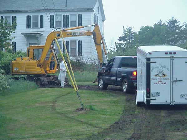a truck with an attatched trailer, next to an excavator truck
