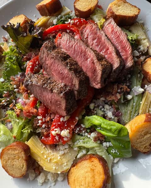 Steak House Salad is one of the most-loved picks at Rivals Brew Pub 🥗 Built on spring mix with a seven ounce flat iron steak, feta cheese crumbles, smoked bacon, artichokes, red onion, roasted red peppers, and pretzel croutons. 🔥 #RivalsBrewPub #SteakHouseSalad #PubFavorites