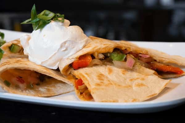Quesadilla is one of the most-ordered favorites at Rivals Brew Pub 🧀 Packed in a warm flour tortilla with Monterey-Cheddar Jack cheese, pico de gallo, sour cream, and salsa, it's the kind of pick guests come back for again and again. 🌮 #RivalsBrewPub #Quesadilla #PubFavorites